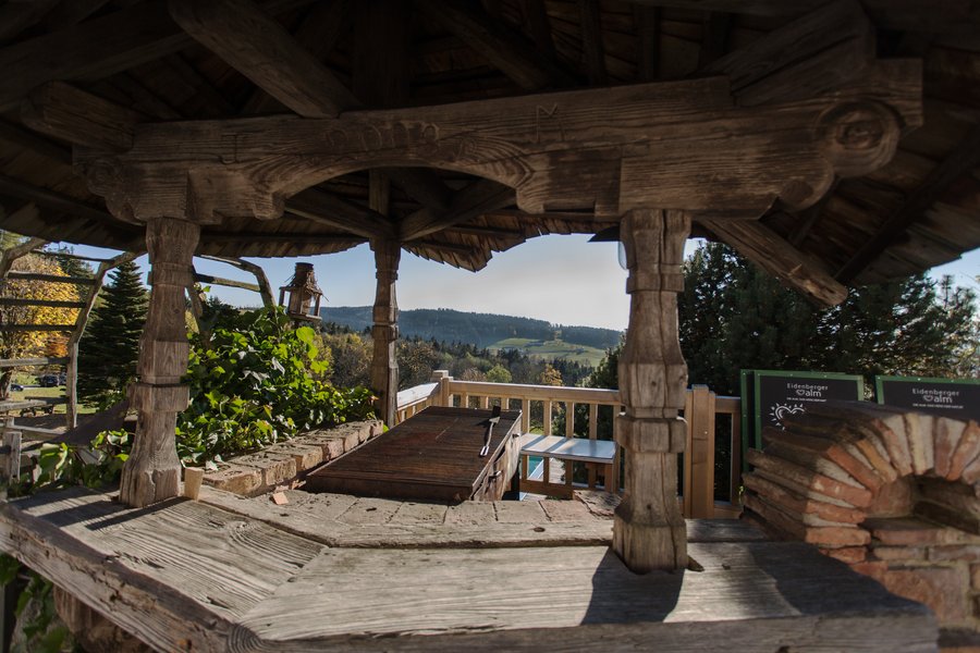 Herbstlicht im Mühlviertel – Außenaufnahme für die Eidenberger Alm Holzpavillon mit Blick auf herbstliche Mühlviertler Landschaft bei tiefstehender Sonne