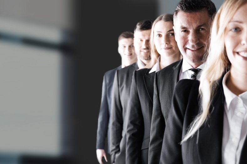 Teamfoto modern Unternehmen Teamfoto eines Unternehmens in Businesskleidung – Mitarbeiter in Reihe angeordnet