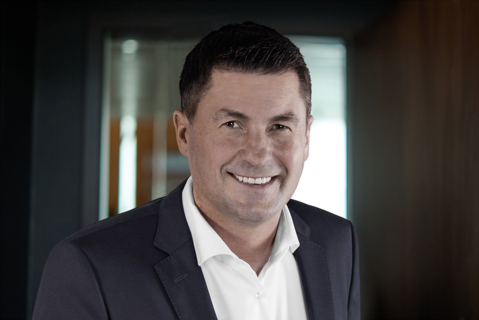 Businessporträt Mitarbeiter natürlich Authentisches Businessporträt eines Mannes im Büro – Mitarbeiterfoto mit natürlicher Ausstrahlung